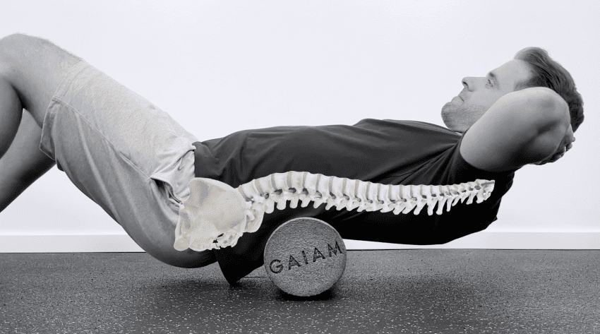 A person using a multi-density foam roller for a sore back to massage and release tight muscles.