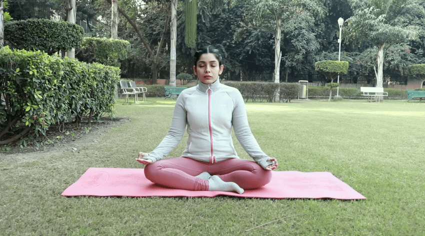 A person demonstrates a simple pose for practicing belly breathing at home.