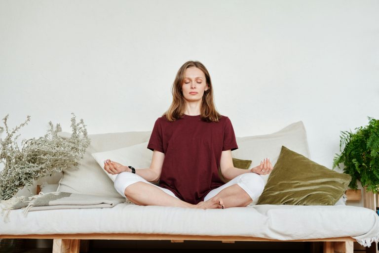 A person is calmly sitting in a peaceful room, practicing the best morning mindfulness meditation routine.