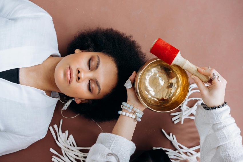 A person is playing a beautiful, ornate Tibetan Singing Bowl, creating relaxing sound vibrations for meditation.