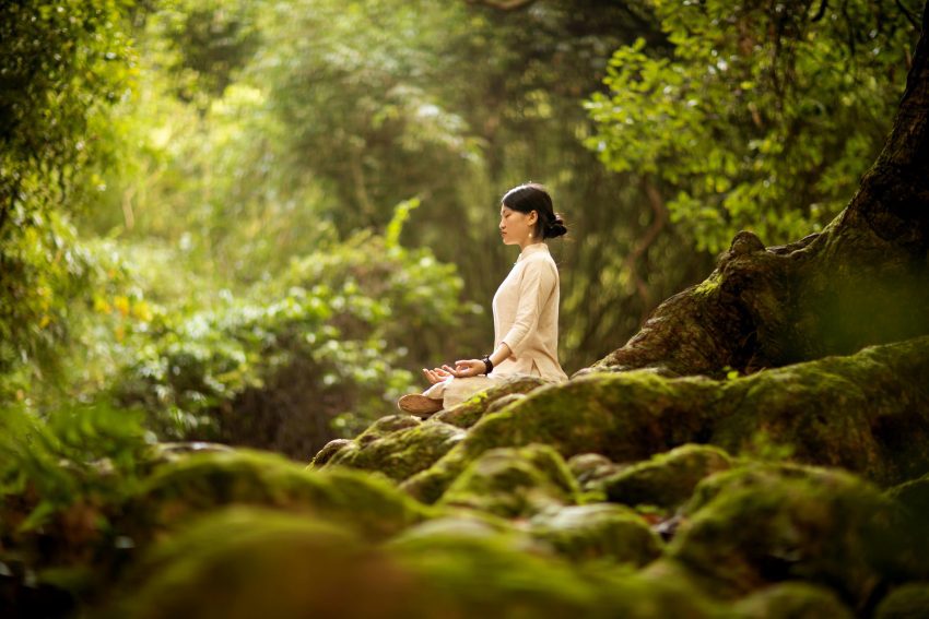 A serene person sits in a cross-legged yoga pose illustrating the peace found through yoga for wellness.